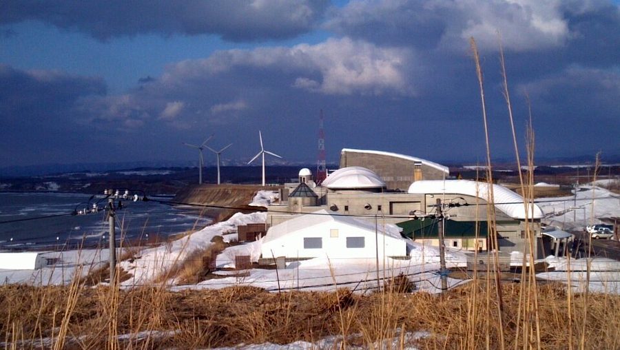 とままえ温泉ふわっとの建物と、背後に連なる風力発電の風車群