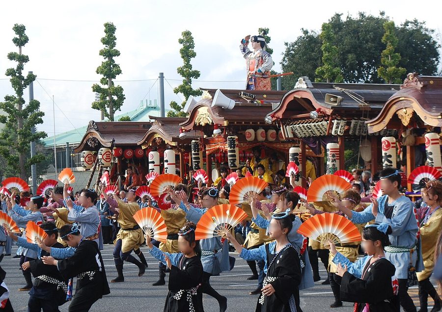 八街の祭りで山車とともに扇子を手に踊る人々