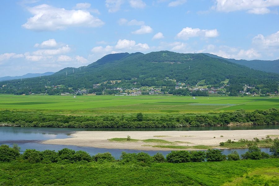 北上川沿いの田園地帯と対岸の束稲山を望む眺め