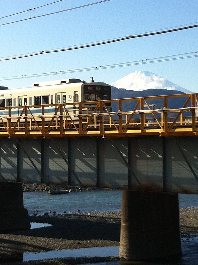 酒匂川に架かる鉄橋を渡る小田急線の電車と富士山