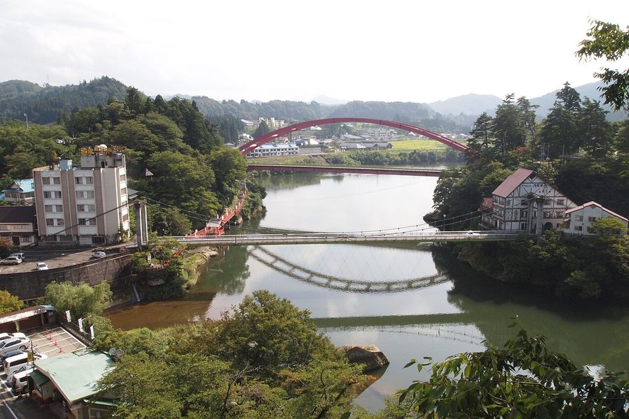 只見川に架かる赤い橋と川沿いの旅館