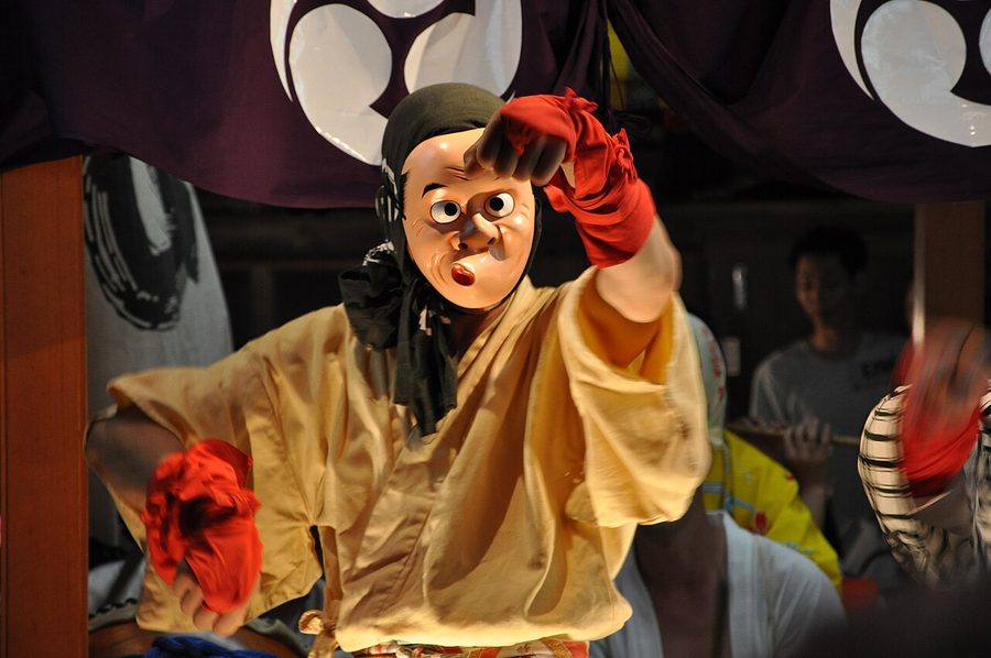 八坂神社の祇園祭で、ひょっとこ面をつけて踊る男性